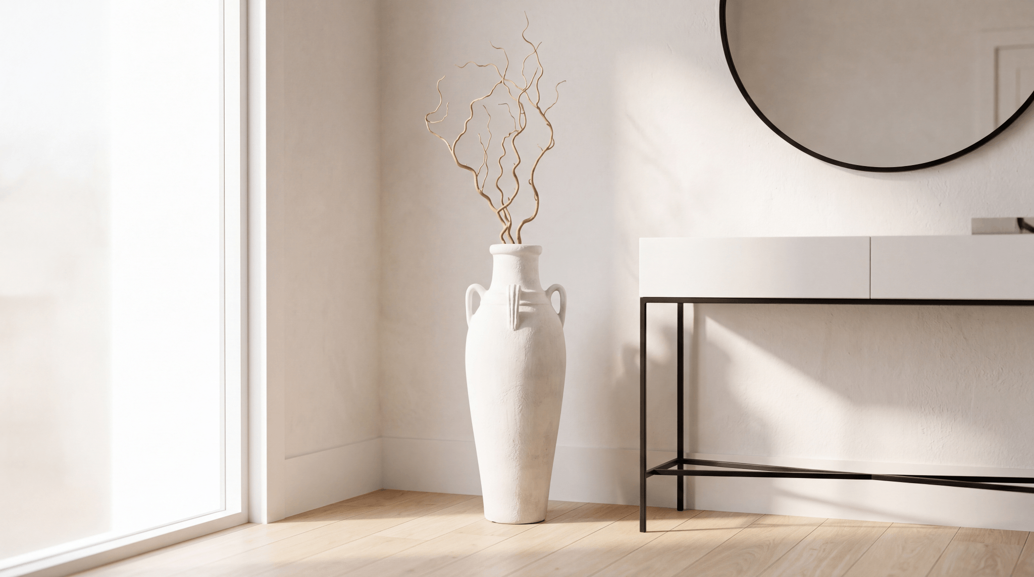 Tall white ceramic floor vase with curly willow branches anchoring an entryway